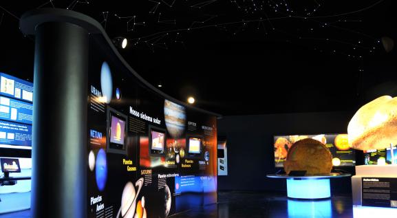 Descrição da imagem: Seção da astronomia. A esquerda painel escrito: Nosso sistema solar. A direita, maquete do sol redondo de cor amarela. 