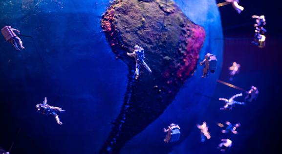 Imagem do globo terrestre com diversos astronautas sobrevoando