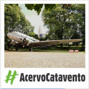 Foto do avião Douglas DC-3 no jardim externo do Museu Catavento. Na parte inferior da foto escrito: #AcervoCatavento