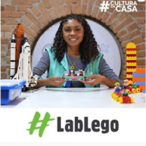 Foto de uma mulher sorrindo de colete verde segurando algumas peças de LEGO