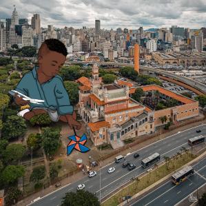 Foto do Palácio das Indústrias, ao fundo vários prédios da cidade de SP e a ilustração de uma criança com camisa azul segurando um aviaão