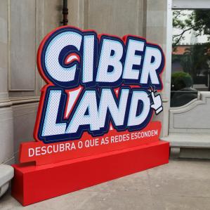 foto de um painel na exposição escrito "ciber land"