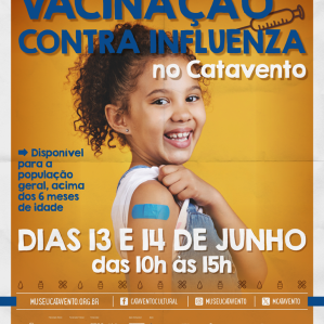 Uma criança de cabelos cacheados mostrando o braço e com um curativo azul simulando que tomou vacina