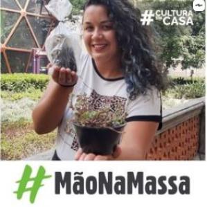 mulher sorrindo com uma planta dentro de um saco plástico